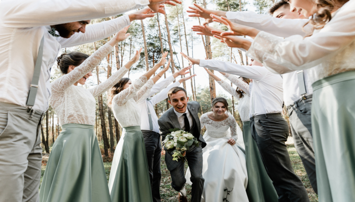 bride and groom run among the company of friends