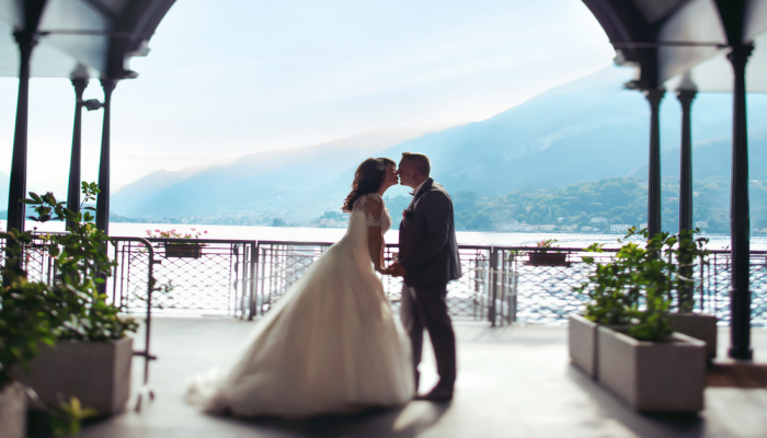 bride and groom kissing in front of mountains